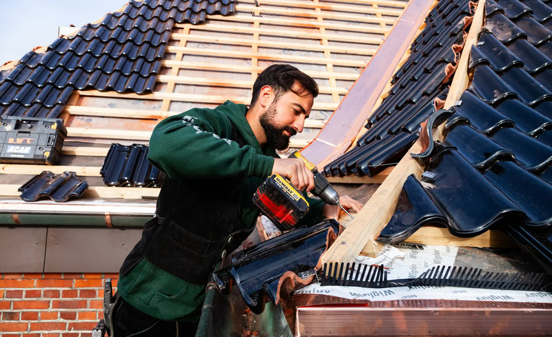 Dachdecker mit Bohrer in der Hand