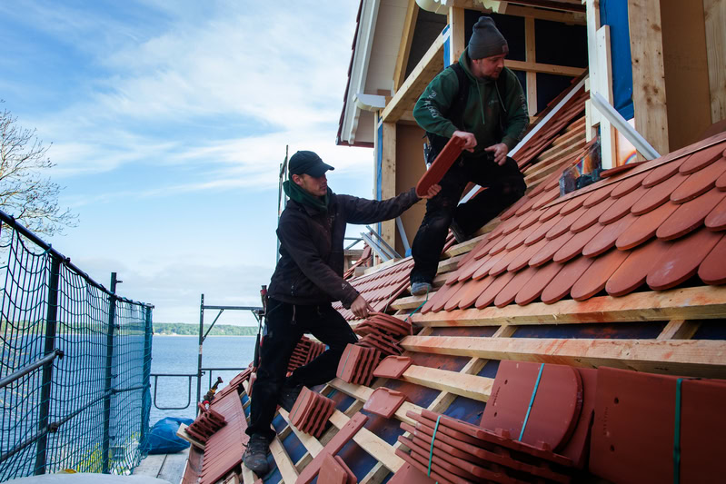 Zwei Dachdecker auf einem Dach